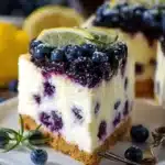 Delicious Lemon Blueberry Cheesecake Cake topped with fresh blueberries and lemon zest.