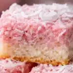 Pink Coconut Snowball Cake Bars topped with fluffy coconut frosting